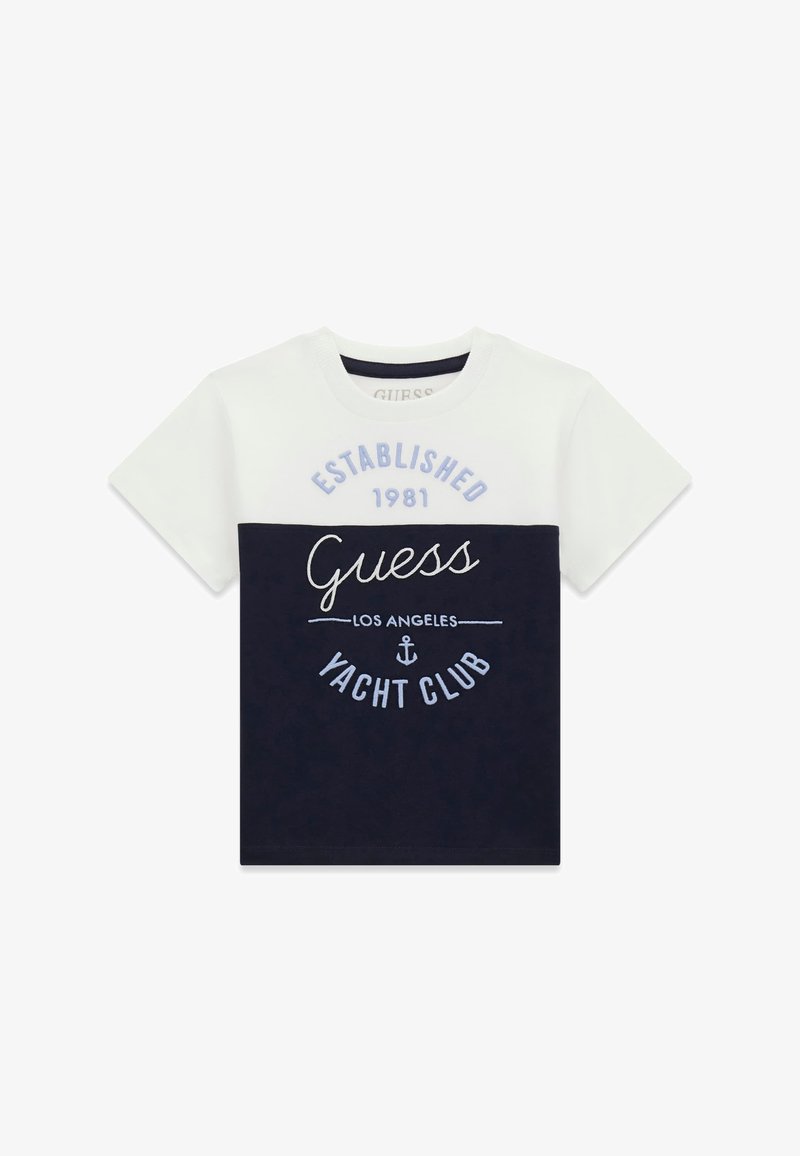 T-shirt à manches courtes à panneaux blanc et bleu marine avec le texte "Guess Los Angeles Yacht Club" et "Established 1981" ainsi qu'un graphique d'ancre.
