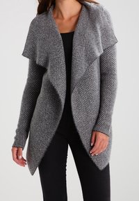Gray herringbone cardigan with open front, long sleeves, and draped collar. Soft, textured knit fabric. Fitted silhouette with side pockets.