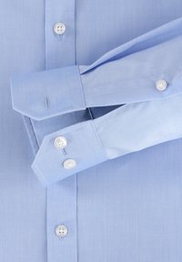 Lichtblauwe overhemd met kraag en lange mouwen, met witte knopen en een soepele stofstructuur. De manchetten zijn puntig met knoopaccenten.