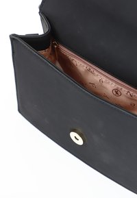 Černá kožená kabelka s hladkým povrchem. Uvnitř se nachází světle růžová podšívka s embosovanými písmeny a zipovou kapsou. Zlaté kovové doplňky.