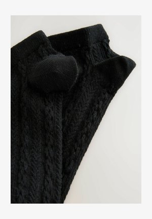 Juodos megztos kojų šiltesnės su tekstūriniais raštais, turinčios storą juostą viršuje ir suapvalintą pūkuotą detalę šone.