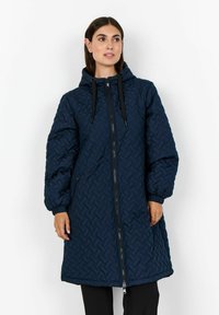 Mornarska dugulja s kapuljačom od quilted materijala, s geometrijskim uzorkom, prednjim zatvaračem i vezicama na kapuljači i manžetama.