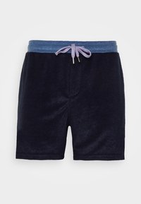 Shorts en velours bleu marine avec une taille élastique bleu clair et un cordon de serrage mauve clair noué en nœud à l'avant.