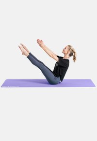 Tappetino da yoga viola con una persona che esegue un sollevamento delle gambe da seduto. Indossa una maglietta nera e leggings scuri, dimostrando flessibilità e forza del core.