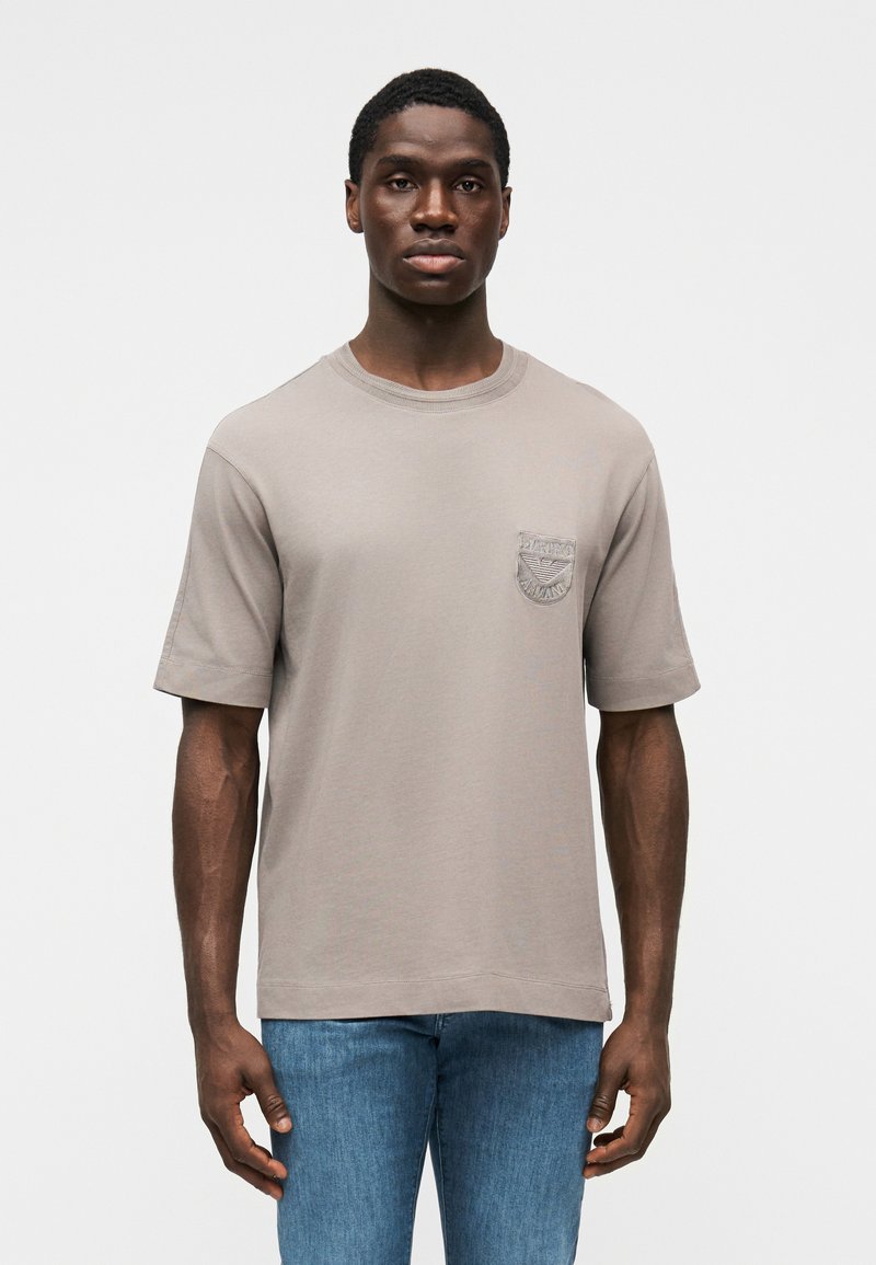 Gray short-sleeve T-shirt in a relaxed fit, featuring a textured pocket on the left side. Made from soft cotton blend fabric.