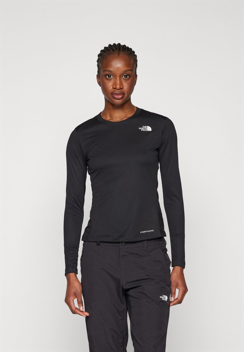 Maglietta nera a maniche lunghe realizzata in tessuto testurizzato, con un piccolo logo bianco sul petto e un'etichetta all'orlo.