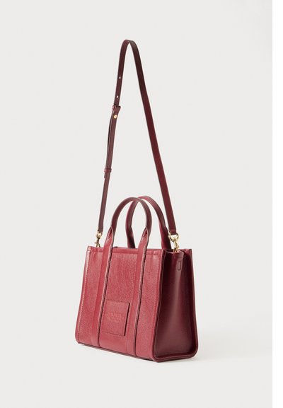 Rdeča usnjena torba z teksturo, z dvojno zgornjo ročico, odstranljivo dolgo naramnico z zlatimi detajli in reliefno sprednjo podrobnostjo.