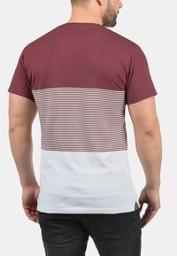 Maroon and white short-sleeve t-shirt featuring horizontal maroon-and-white stripes across the upper back. Straight hem, soft fabric.