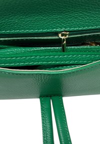 Zelená texturovaná kožená kabelka se zipovým zavíráním, s hladkými okraji a dvěma plochými popruhy na nošení. Uvnitř jsou přihrádky.