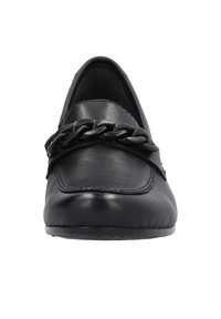 Mocassins en cuir noir avec une semelle plate, dotés d'un accent en chaîne noire proéminente sur le dessus. Texture lisse et design épuré.