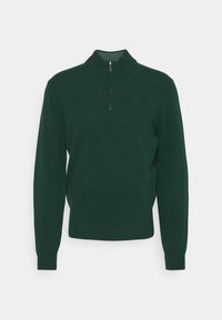 Pull en maille vert foncé à manches longues avec un col haut et une courte fermeture éclair à l'avant, présenté sur un fond blanc uni.