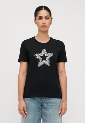 T-shirt en coton noir avec un grand design d'étoile en argent fabriqué de sequins, col rond et manches courtes. Coupe classique, sans motifs visibles.