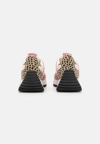 Des chaussures de sport multicolores avec un design à motifs de léopard, des accents roses et une semelle noire texturée, montrant une vue arrière.