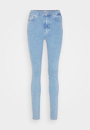 Svetle modré džíny s vysokým pasem a skinny střihem, vyrobené z denimu. Obsahují pět kapes a zapínání na předním knoflíku. Hladký povrch s mírným opruzením.