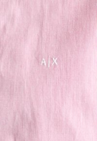Stripet rosa stoff med et subtilt mønster og brodert "A.X."-logo i hvitt. Glatt tekstur med fine detaljer.