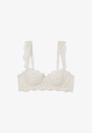 Lace bralette in ivory with floral pattern, underwire support, wide lace-trimmed straps, and a sheer texture. Adjustable back closure.