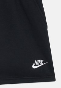 Fekete sport rövidnadrág sima anyagból, oldal zsebekkel és az alsó jobb részen hímzett fehér Nike logóval.