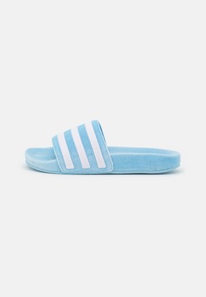 Sandale slide bleu clair avec une large bride comportant trois bandes blanches parallèles et une semelle rembourrée.