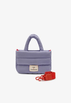 Lavendel gekwilt stoffen handtas met korte handvatten, een logo-badge aan de voorkant en een afneembare rood schouderriem met metalen sluitingen ernaast.