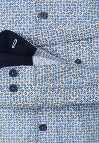 Een overhemd met knoopsluiting dat een geometrisch blauw en groen patroon op een witte achtergrond heeft. De marineblauwe kraag en knopen versterken het ontwerp.