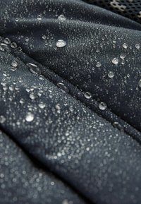 Vodootporna tkanina u tamno sivoj boji s vidljivim kapljicama vode, koja prikazuje glatku teksturu i blagi sjaj, naglašavajući svoju funkcionalnost.