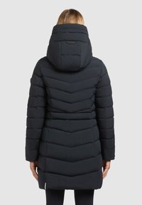 Zwarte pufferjas met een chevronpatroon, voorzien van een hoge kraag en capuchon, gestructureerde stof en een rechte zoom die halverwege de dijen eindigt.