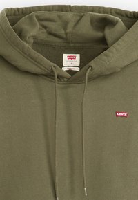 Olíva zöld kapucnis pulóver puha anyagból, húzózsinórral ellátva. A mellkasán apró piros Levi's logó található, valamint egy címke belül.