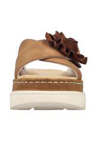 Brown leather slide sandal with a ruffled accent, cross-strap design, cushioned insole, and a white rubber sole.