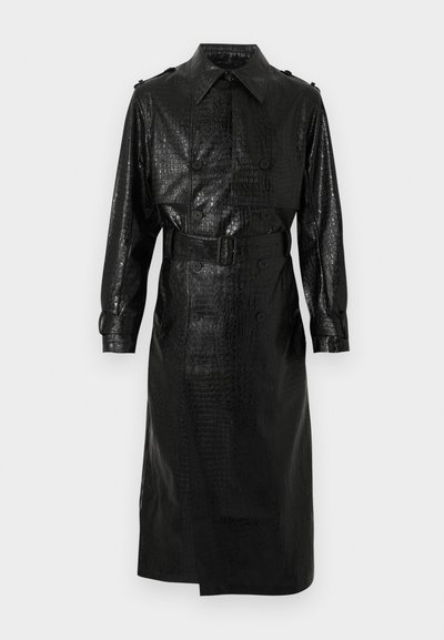 Μαύρο παλτό τύπου τραντσόκο με δερμάτινη όψη κροκοδειλοειδούς, διπλή σειρά από κουμπιά, ζώνη στη μέση, μακριά μανίκια και μυτερό γιακά.