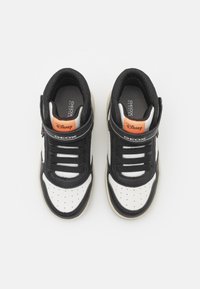 Sneaker in bianco e nero con design alto, materiale traspirante, suola in gomma e marchio Disney arancione sulla linguetta.