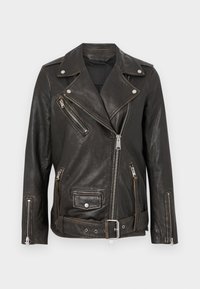 Giacca da biker nera in pelle con tasche con zip, accessori in argento e vita con cintura. Presenta un design asimmetrico classico e una finitura testurizzata.
