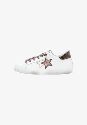 Baskets basses blanches avec une étoile et un tab de talon en bronze métallique, des lacets à imprimé léopard et une semelle blanche légèrement usée.