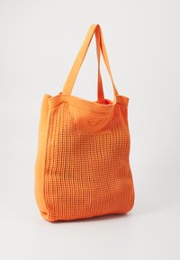 Geantă tote din plasă portocalie, cu două mânere robuste, prezentând un design cu țesătură deschisă și o formă rectangulară. Material ușor și flexibil.
