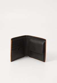 Black leather wallet with tan accents, featuring multiple card slots and a secure pocket. Interior showcases smooth texture and clean design.