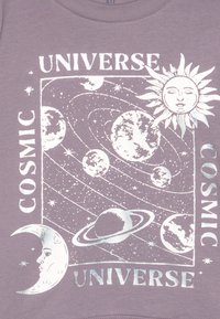 Lila Baumwollhemd mit metallisch silbernen, kosmisch inspirierten Grafiken: Sonne, Mond, Planeten und Sterne sowie dem Text "KOSMISCHE UNIVERSE".