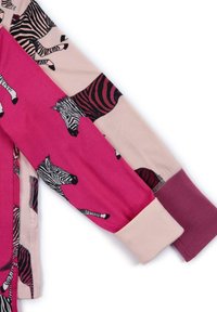 Dragkedja på toppen med långa ärmar, en rosa ärm och en beige ärm med zebramönster. Mjuk tyg med kontrasterande manschetter.