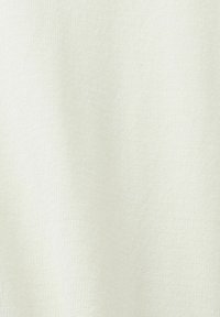 Tissu en maille beige clair avec une surface texturée, présentant un motif côtelé fin. Matière douce et extensible.