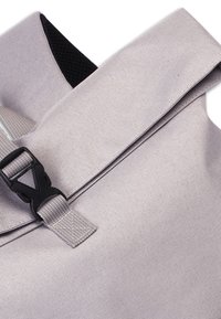 Grijze stoffen rugzak met een oprolontwerp, voorzien van een zwarte plastic gesp en textielmateriaal, dat duurzaamheid en functionaliteit benadrukt.