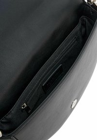 Sac bandoulière en cuir noir avec une texture lisse, doté d'une poche zippée et d'une fermeture à pression métallique. L'intérieur présente une doublure en tissu.