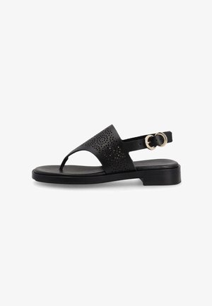 Sandalo nero piatto con design floreale traforato, anello per il dito, cinturino regolabile alla caviglia e doppia fibbia dorata su suola con tacco basso.