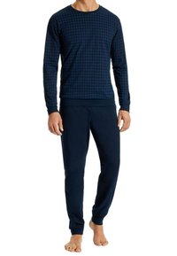 Ensemble de détente bleu marine comprenant un haut à manches longues avec un motif à carreaux et un pantalon unicolore assorti, fabriqué en tissu doux avec des poignets côtelés.