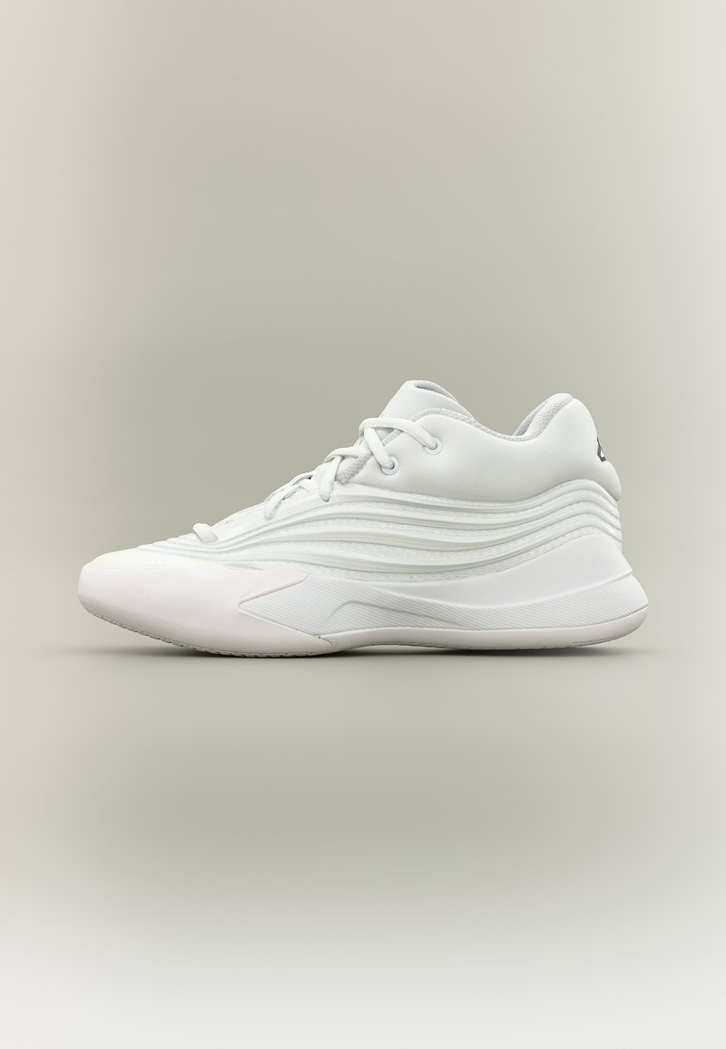 Zapatilla deportiva blanca con lados de patrón ondulado, cierre de cordones y suela gruesa sobre fondo degradado neutro.