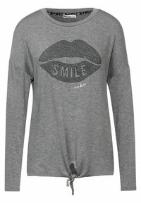 Graues Langarm-T-Shirt mit einem Knoten-Detail am Saum, versehen mit einem Lippen-Graphic aus schwarzen Rhinestones und dem aufgedruckten Text "SMILE."