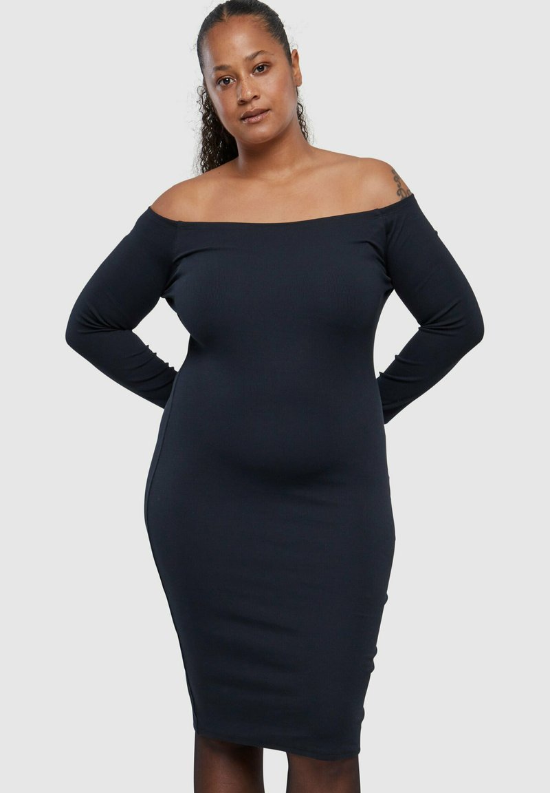 Svart, ribbet off-shoulder kjole med lange ermer, figurnær silhuett som når midt på leggene, glatt tekstur og minimalistisk design.