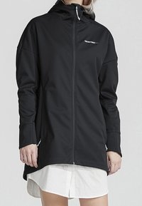 Černá softshellová bunda s kapucí, plným zipem, dlouhými rukávy a bočními zipovými kapsami. Vyrobena z hladké tkaniny s elegantním siluetou.