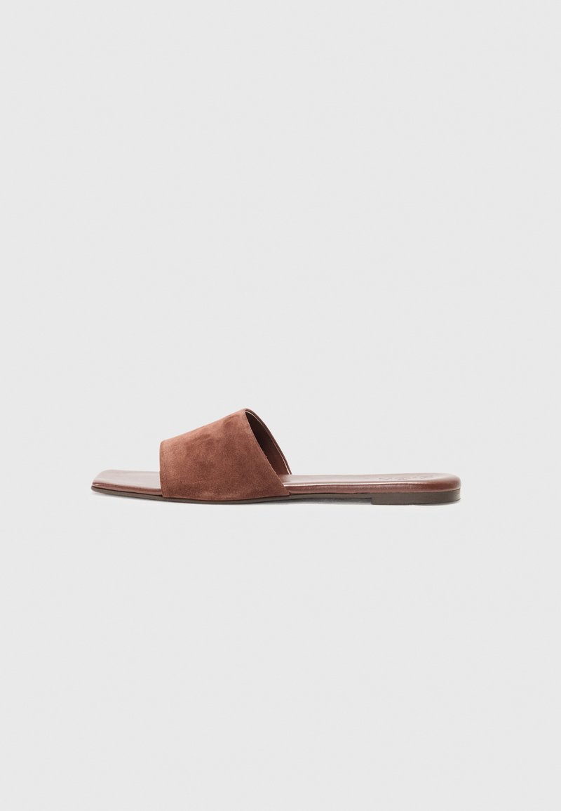 Brune semsket slip-on sandaler med en bred stropp, flat såle og minimalistisk design. Glatt tekstur med en matt finish.