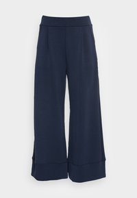 Granatowe spodnie o szerokich nogawkach z miękkiego materiału, z gładkim elastycznym paskiem w talii, plisami oraz luźnym krojem z podwiniętymi nogawkami.