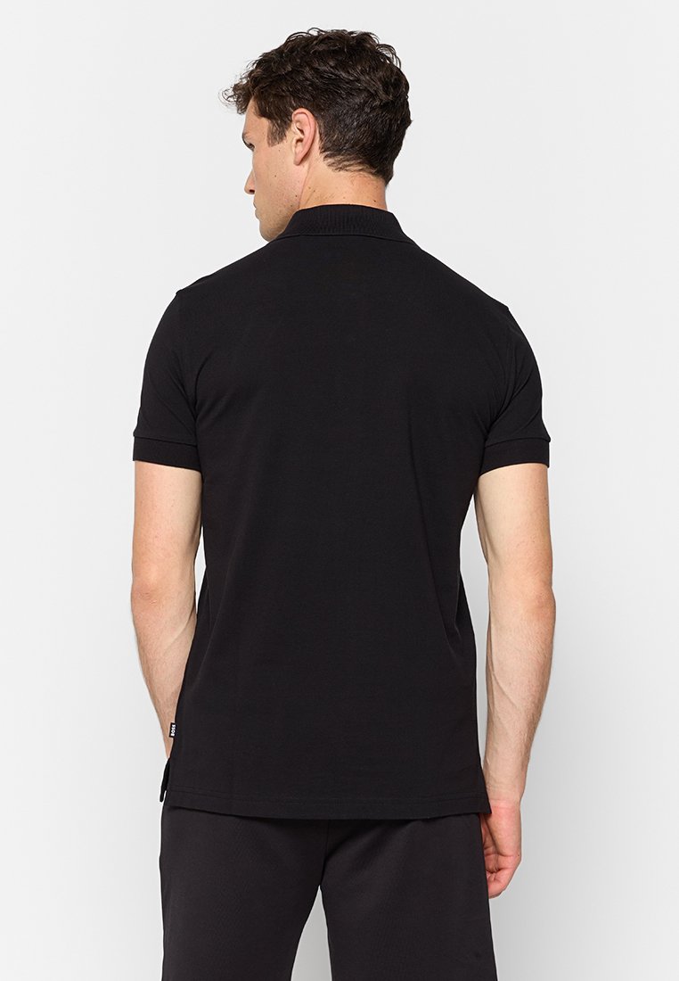 Polo noir, à manches courtes, en tissu de coton doux, col classique, design minimaliste, ourlet droit, adapté à un usage décontracté.