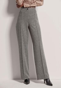 Grijze herringbone brede pijpen met een hoge taille en naden aan de voorkant. Gepaard met zwarte spitse hakken, met een knoop in de taille.