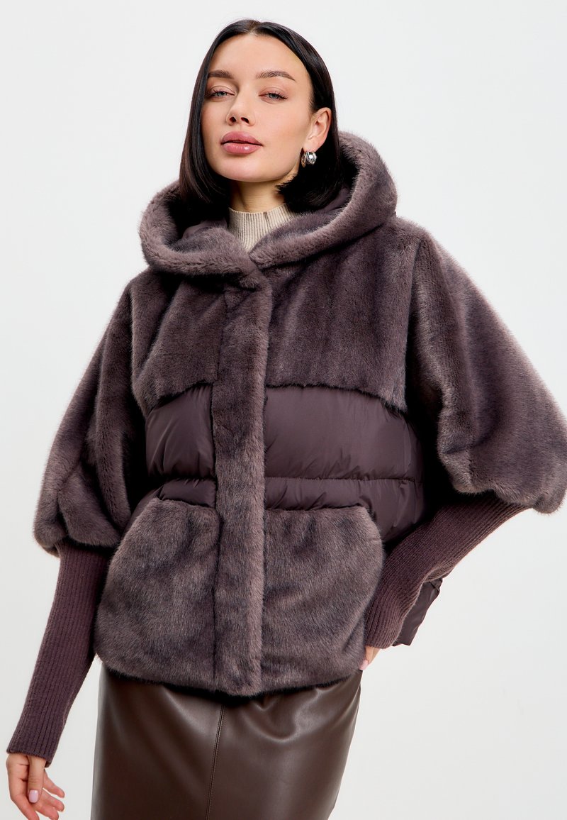 Umělá kožešinová bunda v tmavě šedé barvě, s nadýchaným designem a kapucí. Obsahuje elastické rukávy, přední kapsy a měkkou texturu.